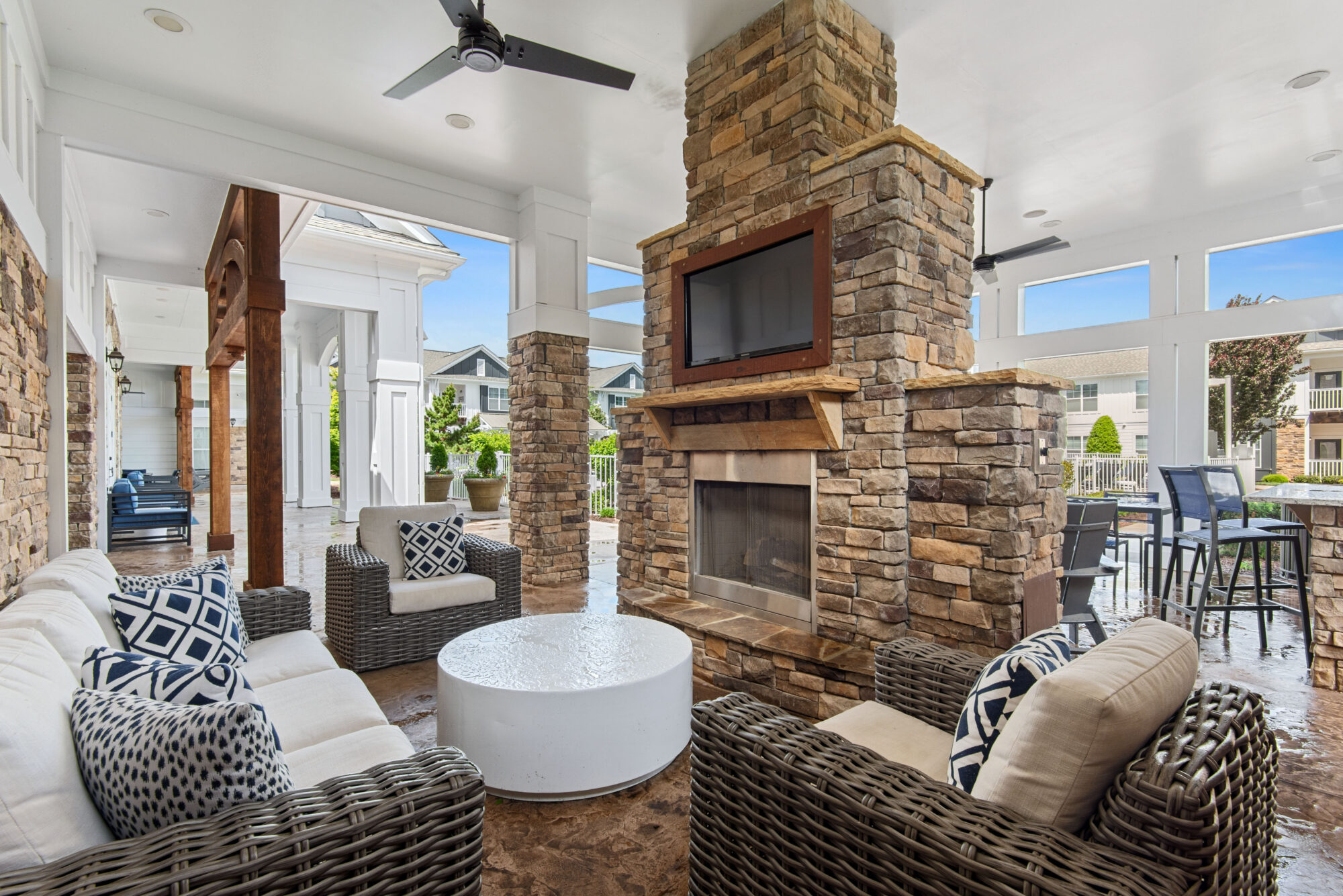 Covered patio with arm chairs around a fire place